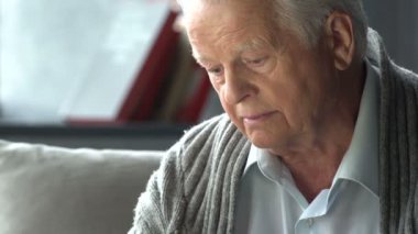 yaşlı beyaz adam modern bir dairede bir kitap okuma