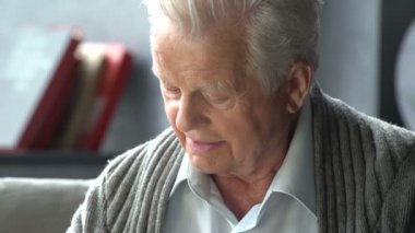 yaşlı beyaz adam modern bir dairede bir kitap okuma