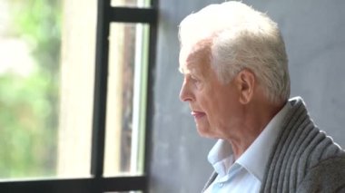 ciddi üst düzey emekli adam, ilgili, çay içme ve kitap okuyarak dikkatini dağıtmak için çalışıyor