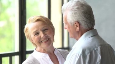 güzel ve mutlu yaşlı çift konuşmak ve gülümseme. kameraya bakan kadın