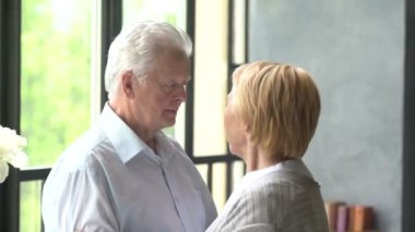 sevgi dolu ve mutlu yaşlı çift modern bir daire. Onlar konuşma ve gülümseme