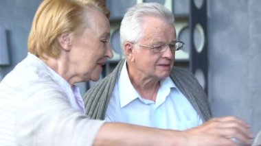 Yaşlı çift rahat oturma odasında internette aile ile iletişim içinde eğleniyor