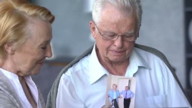 Yaşlı çift rahat oturma odasında internette aile ile iletişim içinde eğleniyor