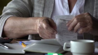 yaşlı kadın faturaları hakkında endişelenir. o Hesap makinesinde dikkate alır ve altüst olur