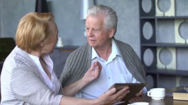 Yaşlı çift rahat oturma odasında internette aile ile iletişim içinde eğleniyor