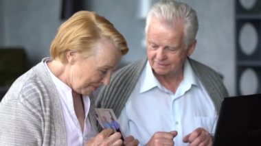 Yaşlı çift rahat oturma odasında internette aile ile iletişim içinde eğleniyor