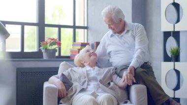 sevgi dolu ve mutlu yaşlı çift modern bir daire. Onlar konuşma ve gülümseme