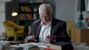 yaşlı adam faturaları hakkında endişelenir. o Hesap makinesinde dikkate alır ve altüst olur