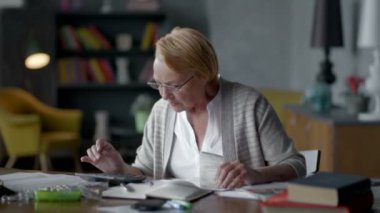 yaşlı kadın faturaları hakkında endişelenir. o Hesap makinesinde dikkate alır ve altüst olur