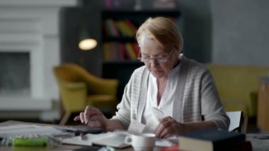 yaşlı kadın faturaları hakkında endişelenir. o Hesap makinesinde dikkate alır ve altüst olur