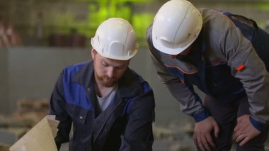 Mühendisler planları binasında bakmak ve ağır sanayi fabrikası inşaat aşamalarında tartışmak