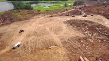 kamyon ve Ekskavatör göl ve orman yakınında bir yere inşaat sitesinin havadan görünümü