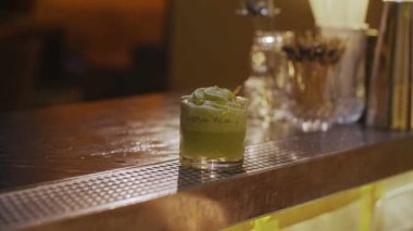 Barmen yakından yeşil alkollü kokteyl lüks barda sunar.