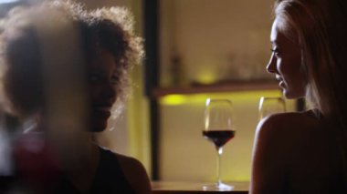 Lüks barda şarap kırmızı içme genç güzel zenci ve sarışın kızlar. Ön plan temizleyin Şarap kadehi