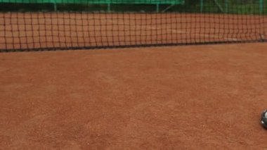 Tenis raketi ve yeni boyanmış tenis kortunda yeni bir tenis topu.