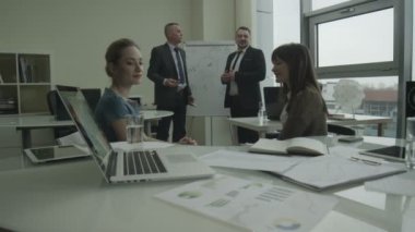 kendinden emin ve mutlu bir iş takım karışık yaş ve etnisite bir ışık, modern ofis binası toplantı tutuyorsun. onların iş geliştirme fikirleri görüşüyorlar