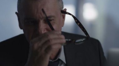 Eski işadamı eğildi geri onun ofis koltuğu, o gülümseme ve hayal