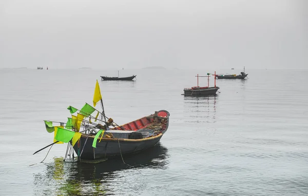 Wooden fishery boats in the sea with fog