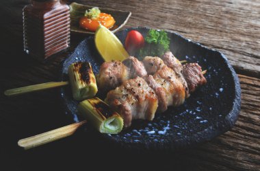 Izakaya barında ızgara edilmiş Japon usulü domuz şişleri, düşük aydınlatma ve koyu gölgeli servis edilir..