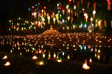 Tayland 'da Loi Krathong Festivali sırasında nehir kenarında mum ve fener asma kabusu. Sahne ışık, su ve kültürel güzellik arasındaki uyumu yansıtıyor..