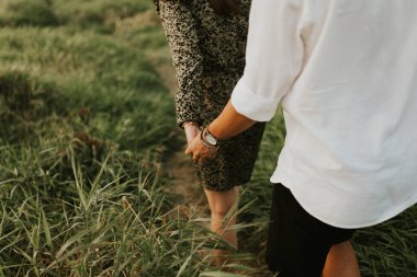 Birbirine aşık çiftlerin el ele tutuşması. El ele tutuşan iki kişi. Sembol, samimi duygular, şefkat ve sevilen birini işaret eder. Romantik bir yürüyüş yapan bir çift. 14 Şubat. Doku