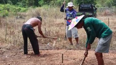 Linggang Bigung, Batı Kutai, Doğu Kalimantan, Endonezya - 1 Kasım 2025 - insanlar çapaları kullanarak toprağı düzleştiriyor