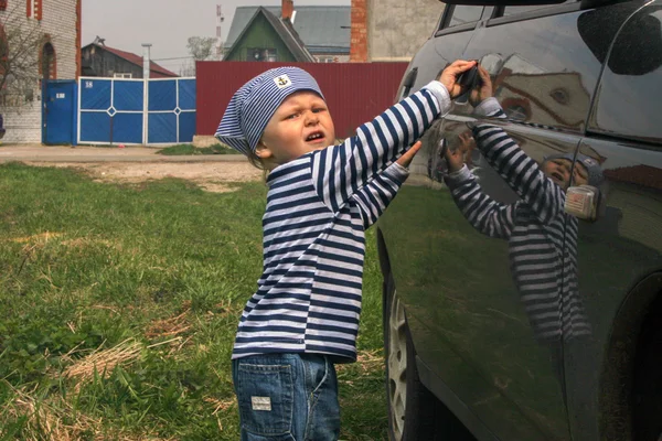 Jongen spelen met rode auto, Rusland — Stockfoto