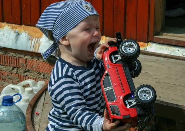 Παιδί παίζει με κόκκινο αυτοκίνητο, Ρωσία — Φωτογραφία Αρχείου