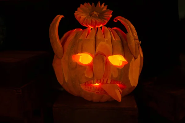 Lâmpada de cabeça de abóbora de Halloween com caras assustadoras no escuro — Fotografia de Stock