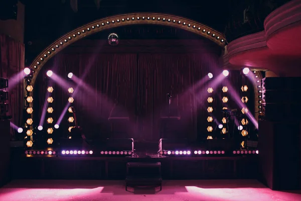 Kleine Bühne mit rosafarbenem Lichtstrahl im Dunkeln — Stockfoto