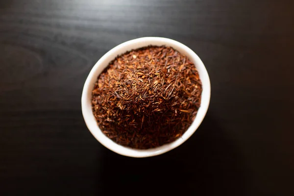 Rooibos tea fehér tányéron egy fa asztalon — Stock Fotó