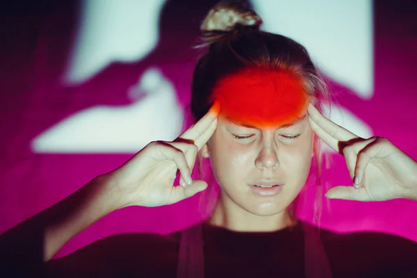 Baş ağrısı ve kırmızı alnı olan genç bir kadın. — Stok fotoğraf