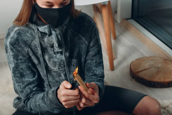 Erwachsene reife Frau macht Yoga zu Hause Wohnzimmer zündet Feuerzeug mit Palo Santo Stock Baumweihrauch — Stockfoto