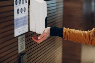 Duvar monte edilmiş dezenfektan dezenfektan ve el.