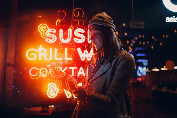 Jong aziatische millennials vrouw in straat stijl mode in neon licht belettering signboard — Stockfoto