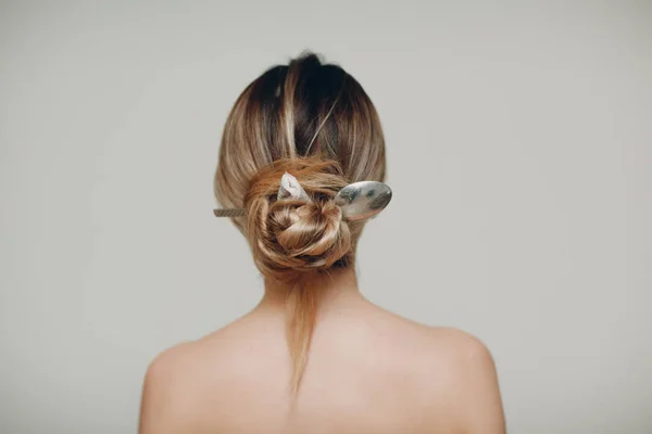 Mulher com colher de metal em seu cabelo penteado de volta — Fotografia de Stock
