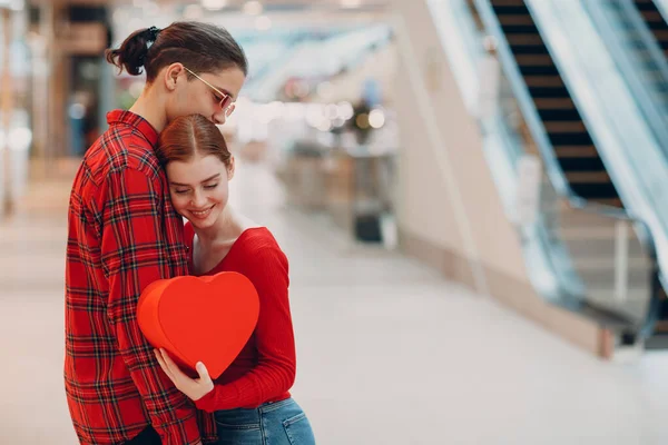 Bella felice giovane coppia con shopping bags in scala mobile centro commerciale — Foto Stock