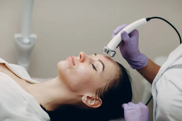 Primer plano de la mujer principal que recibe fonofóresis electroporación terapia facial en el salón de spa de belleza. — Foto de Stock