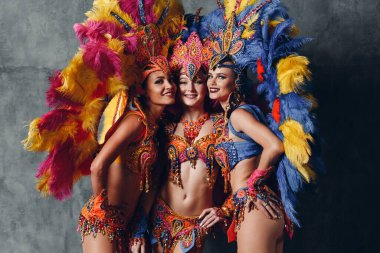 Renkli tüyleri olan Brezilya Samba Karnavalı kostümlü üç kadın.