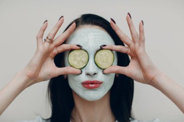 Güzeller güzeli bir kadın portresi. Güzellik salonunda gözleri salatalıklı kilden bir maske takıyor.