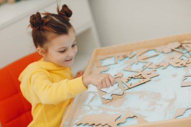 Küçük kız kum biçimli oyuncakla oynuyor. Erken yaşta eğitim. Yürüyen bilişsel psikoloji kavramı.