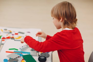 Little boy kid child constructor checking technical toy. Children Robotics constructor assemble toy robot.