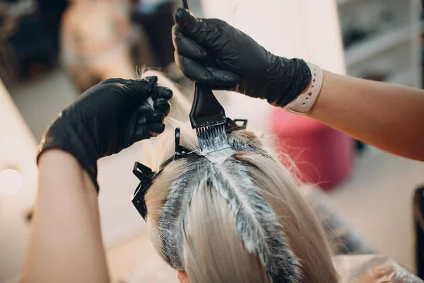 Cabeleireira jovem morrendo de cabelo no salão de beleza. Raízes de cabelo profissional coloração — Fotografia de Stock
