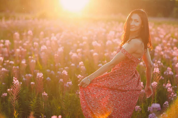 Girl on blooming Sally flower field at sunset. Lilac flowers and woman. — Stock Photo, Image