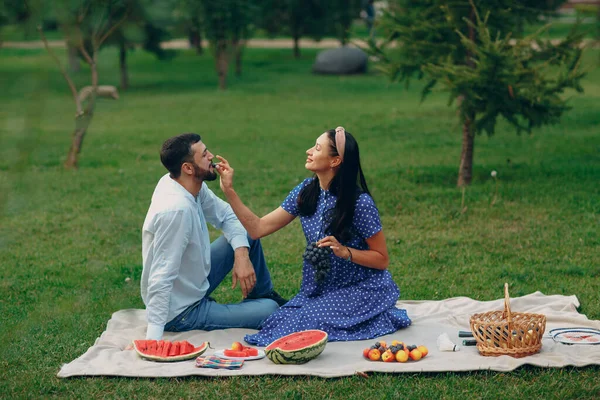 Jong volwassen vrouw en man paar picknick bij groen gras weide in park — Stockfoto