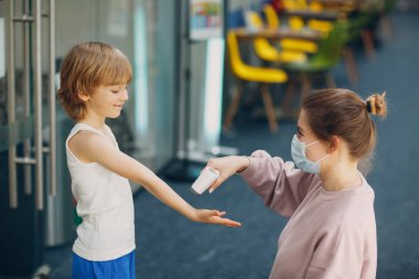Anaokulunda lazer termometreyle çocuk sıcaklığı ölçümü.