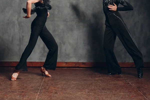 Young couple in black dress dancing in ballroom dance cha-cha-cha. — Stock Photo, Image