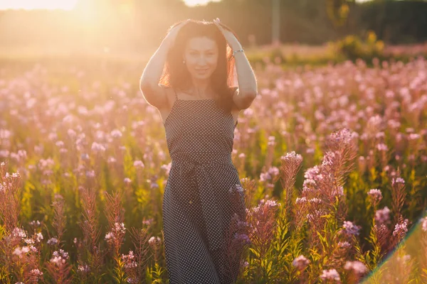 Female brunette on spring blooming sally flower field. Lilac flowers and woman. — Stock Photo, Image