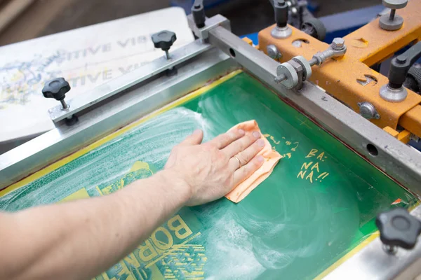 Serigraphy sutra layar proses cetak di pabrik pakaian. Membersihkan Bingkai, squeegee dan cat warna plastisol — Stok Foto