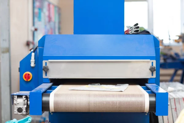 Drying oven for Serigraphy silk screen print process at clothes factory.